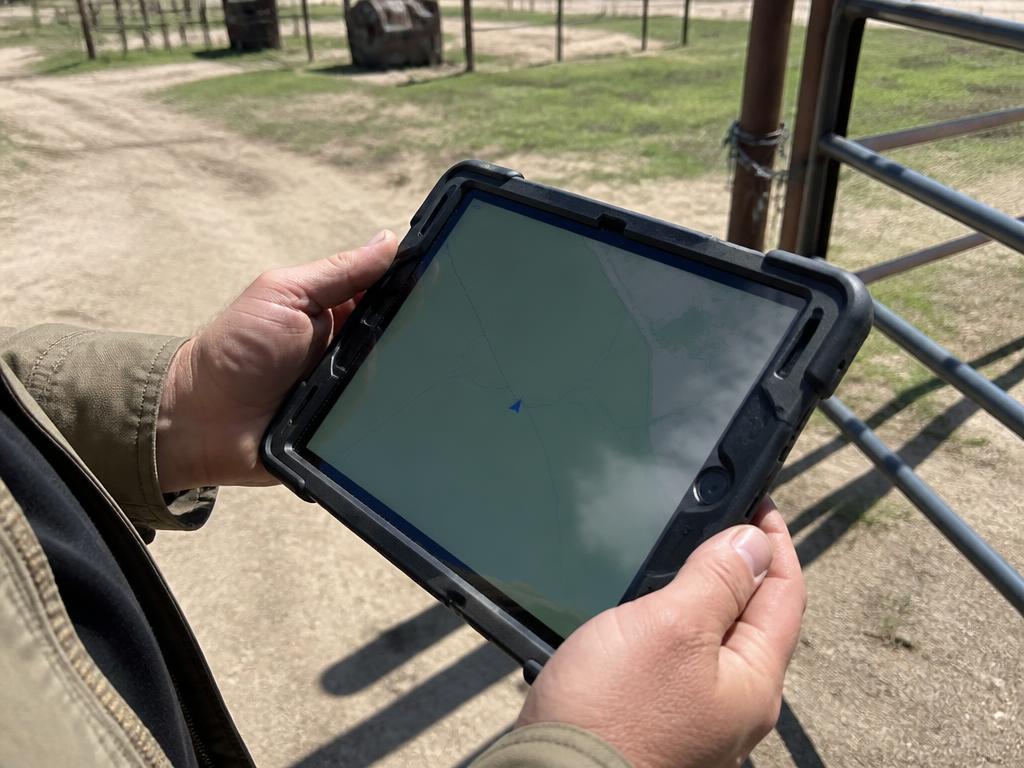 Técnico com tablet de campo consultando o mapa da propriedade rural